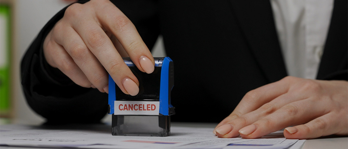 A woman uses a cancelled stamper to stamp a document.